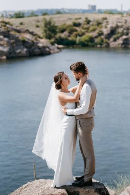 bride blonde girl and groom near the river at sunset light