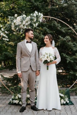 wedding ceremony of the newlyweds on the glade near the restaurant
