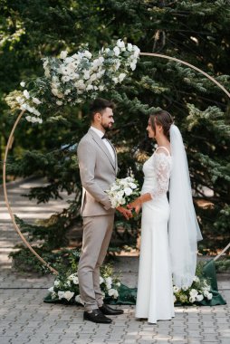 wedding ceremony of the newlyweds on the glade near the restaurant