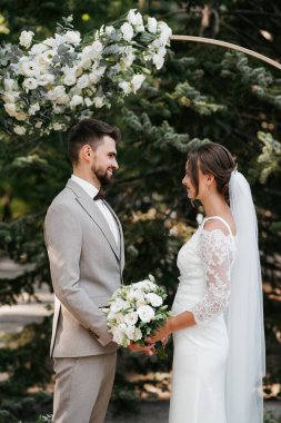 wedding ceremony of the newlyweds on the glade near the restaurant