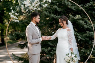 wedding ceremony of the newlyweds on the glade near the restaurant