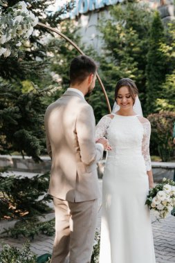 wedding ceremony of the newlyweds on the glade near the restaurant