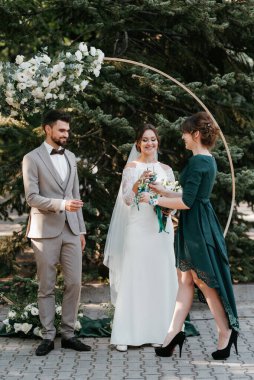wedding ceremony of the newlyweds on the glade near the restaurant