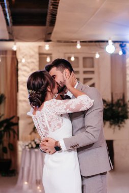 the first dance of the bride and groom inside a restaurant with heavy smoke
