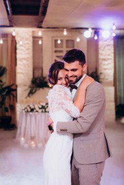 the first dance of the bride and groom inside a restaurant with heavy smoke