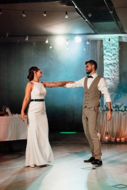 the first dance of the bride and groom inside a restaurant with heavy smoke