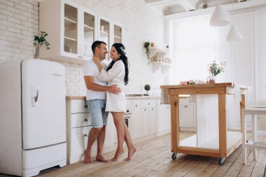 Genç bir çift sabah büyük bir mutfakta.