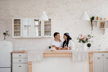 Genç bir çift sabah büyük bir mutfakta.