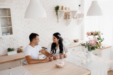 Genç bir çift sabah büyük bir mutfakta.