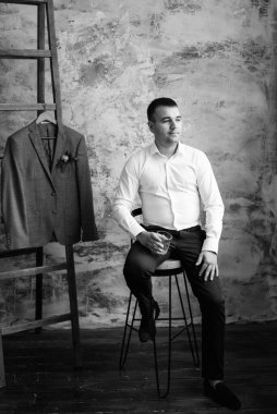 Düğün gününde parlak bir stüdyoda mavi ceketli beyaz gömlekli genç bir damadın portresi.