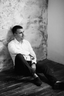 Düğün gününde parlak bir stüdyoda mavi ceketli beyaz gömlekli genç bir damadın portresi.