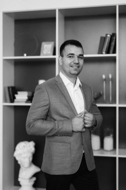 Düğün gününde parlak bir stüdyoda mavi ceketli beyaz gömlekli genç bir damadın portresi.