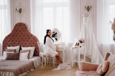 Siyah saçlı gelin kız damadın yatak odasına hazırlanıyor.