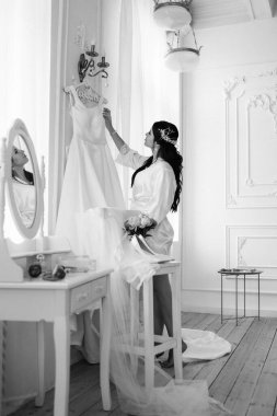 Siyah saçlı gelin kız damadın yatak odasına hazırlanıyor.