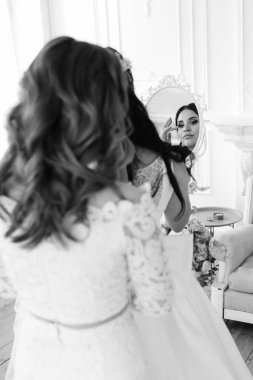 Parlak bir stüdyoda dar bir gelinlik içinde esmer gelin.