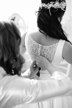 Parlak bir stüdyoda dar bir gelinlik içinde esmer gelin.