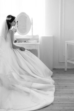 Parlak bir stüdyoda dar bir gelinlik içinde esmer gelin.