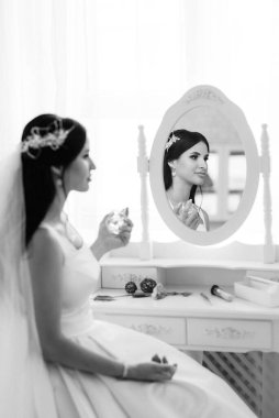 Parlak bir stüdyoda dar bir gelinlik içinde esmer gelin.