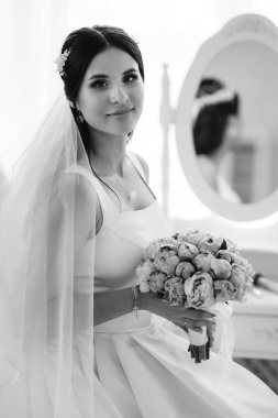 Parlak bir stüdyoda dar bir gelinlik içinde esmer gelin.