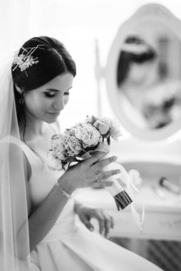 Parlak bir stüdyoda dar bir gelinlik içinde esmer gelin.