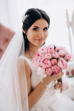 Parlak bir stüdyoda dar bir gelinlik içinde esmer gelin.