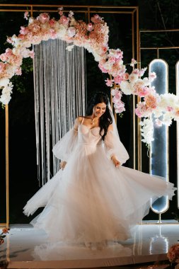 Tüylü beyaz elbiseli gelin akşam kemerinde dönüyor.