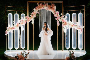 Tüylü beyaz elbiseli gelin akşam kemerinde dönüyor.