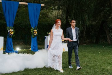 Gelin ve damadın düğün dansı ağır dumanlı yeşil bir çayırda