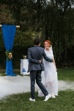 Gelin ve damadın düğün dansı ağır dumanlı yeşil bir çayırda