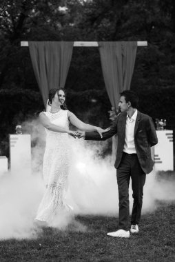 Gelin ve damadın düğün dansı ağır dumanlı yeşil bir çayırda