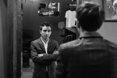 Düğün günü berber dükkanında gri kareli takım elbiseli genç adam.