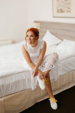 Siyah dantelli gelinlik, sarı buketli otel odasında.