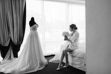 Siyah saçlı gelin kız damadın yatak odasına hazırlanıyor.