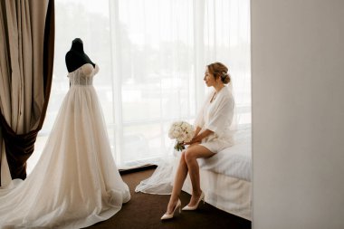 Siyah saçlı gelin kız damadın yatak odasına hazırlanıyor.