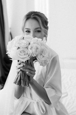 Siyah saçlı gelin kız damadın yatak odasına hazırlanıyor.