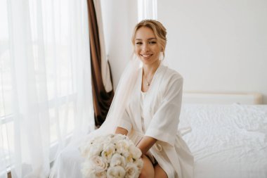 Siyah saçlı gelin kız damadın yatak odasına hazırlanıyor.