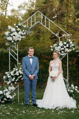 wedding ceremony of the newlyweds on the glade near the restaurant