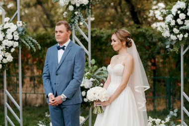 wedding ceremony of the newlyweds on the glade near the restaurant
