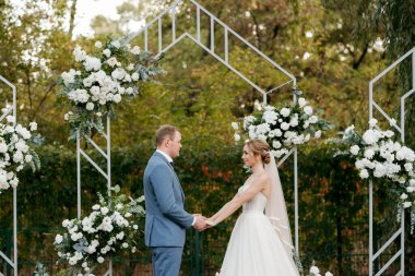 wedding ceremony of the newlyweds on the glade near the restaurant