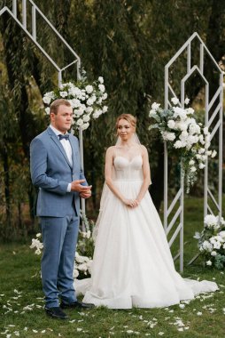 wedding ceremony of the newlyweds on the glade near the restaurant