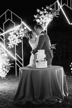 newlyweds happily cut, laugh and taste the wedding cake