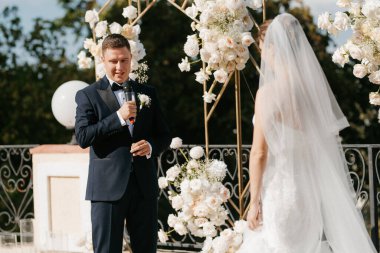 Yeni evlilerin düğün seremonisi nehrin arka planındaki restoranda.