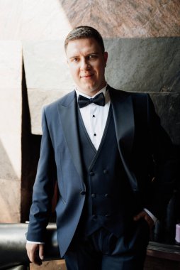 Otel içinde mavi smokinli damadın portresi.