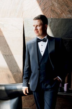 Otel içinde mavi smokinli damadın portresi.