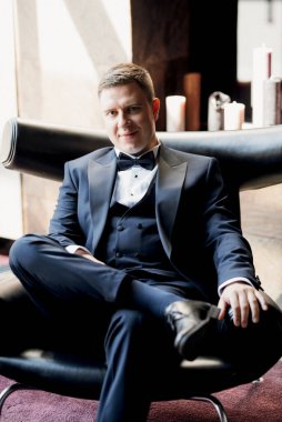 Otel içinde mavi smokinli damadın portresi.