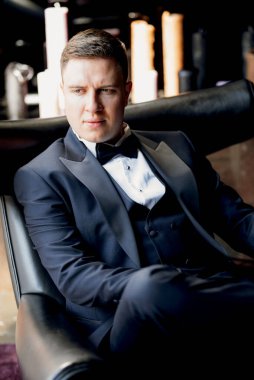 Otel içinde mavi smokinli damadın portresi.