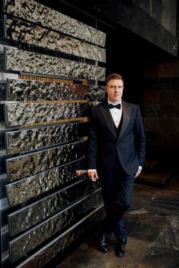 Otel içinde mavi smokinli damadın portresi.