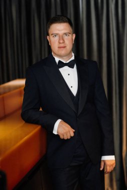 Otel içinde mavi smokinli damadın portresi.