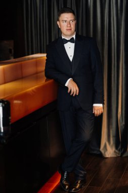 Otel içinde mavi smokinli damadın portresi.