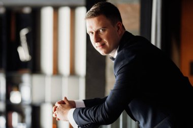 Otel içinde mavi smokinli damadın portresi.